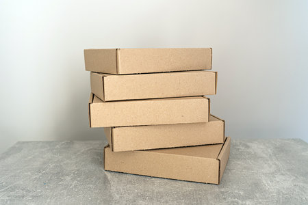 Stack of flat-packed self-assembly cardboard boxes for packaging and gift wrapping.の写真素材