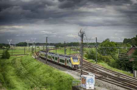 A passenger train following from Brussels to Antwerp, Belgiumのeditorial素材