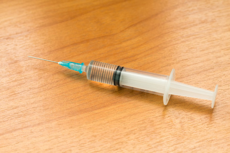 The syringe is placed on a wooden floor,Medical equipmentの写真素材