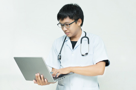 The male doctor is checking the patient's symptoms on laptop,Doctor,Close-up doctor holding laptopの写真素材