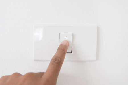 Closeup hand turn off a power button,Finger press light button,Hand with Power plug,interior electric power button in home,Concept switch on light  の写真素材