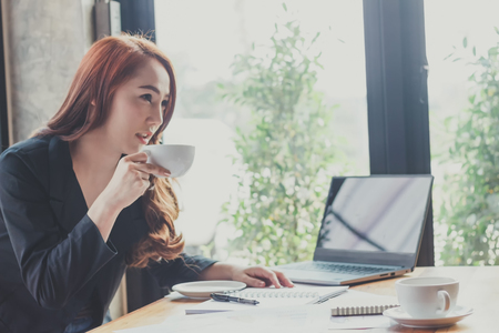 Young woman sit working in a coffee shop,Employees are working outside the company,Students are searching for reports at the restaurant,The girl is shopping online.の写真素材