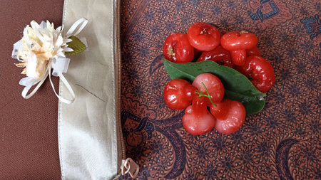 Water guava fruit with leaf on the batik tablecloth, close-up.の写真素材