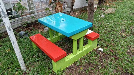 Colorful wooden table and chair in the garden with green grass.の写真素材