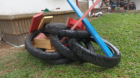 Old tire on the green grass in the garden with wooden boxの写真素材