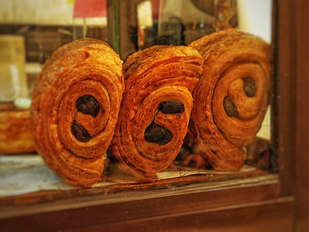 Freshly baked croissants in bakery shop window. Toned.の写真素材