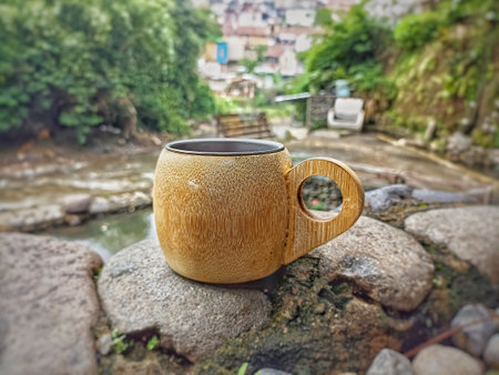 Coffee cup on the stone near the river in the morningの写真素材