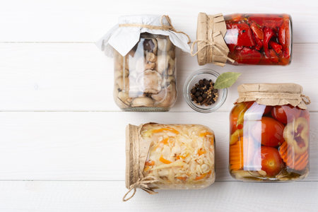 Fermented cultivated vegetables cabbage, tomatoes, peppers, carrots, mushrooms, mix in a glass jar...