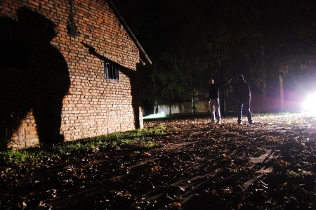two man, one gun and their shadows on a wallの写真素材