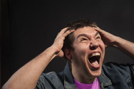 Close-up of a man screaming in agony.の写真素材