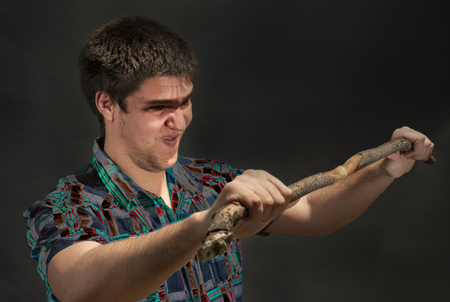 Excited  man broke the stick into two pieces. Studio on black.の写真素材