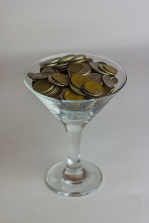 metallic old Russian coin and wineglass martini on a white backgroundの写真素材