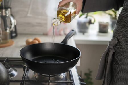 Dripping pan, olive oil and black induction cooker.の写真素材