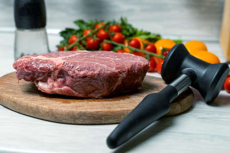 A piece of marbled beef and a chop hammerの写真素材