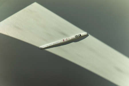 Pregnancy test in female hand on blurred background.の写真素材