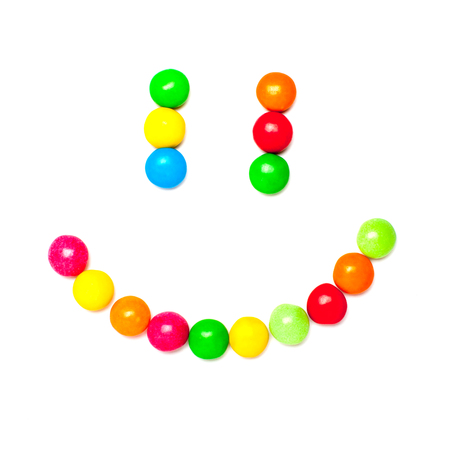 Smiley face made of colorful candies isolated on white background.の写真素材