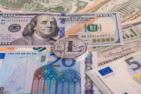 Cryptocurrency coin Litycoin lying on the euro and dollar banknotes. Concept crypto currency electronic money for web banking and international network payments.の写真素材