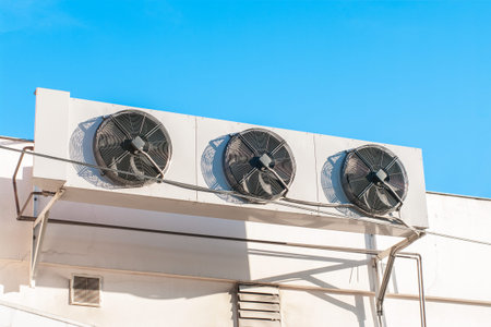 Air compressors installed on the wall of building with sunlight sky.