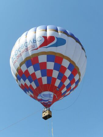 Tver, Russia - May 25, 2013: Hot air balloon with a basket rises in blue sky.のeditorial素材