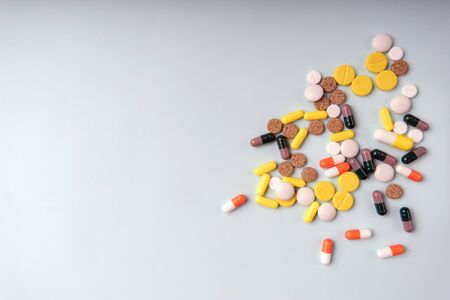 Medicine multicolor pills on grey background closeup with space for text.の写真素材