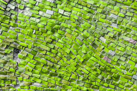 Concrete part of building wall covered with green mosaic. Abstract background. Space for text. Copy...