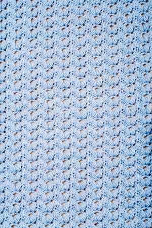 Blue knitted texture with original elegant artful pattern close up. Vertical background. Empty blank for your design.の写真素材