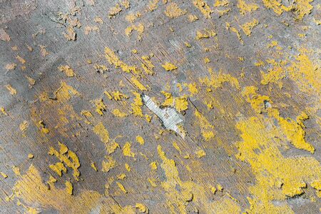 Wooden panel with badly peeling, cracked yellow paint and chipped piece of surface in center of sheet. Old natural grunge textured wood texture for your design.の写真素材
