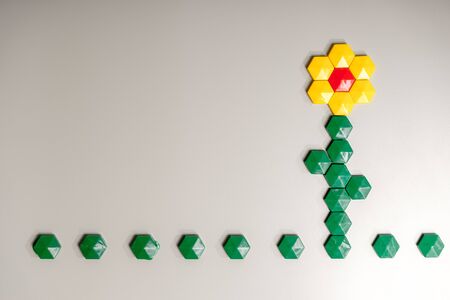 Flower made from children's mosaic, magnets on iron surface for your design with copy space and place for text. Leisure of child, development of fine motor skills and abstract thinking.の写真素材