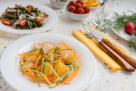 Delicious spring vitamin healthy salads closeup of orange, radish, cucumber, cherry tomato, green beans and healthy vegetable snacks.の写真素材