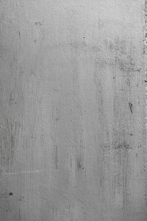 Concrete texture of wall with rough surface painted in silver color with sharp brushstrokes and unpainted areas. Abstract vertical background.の写真素材