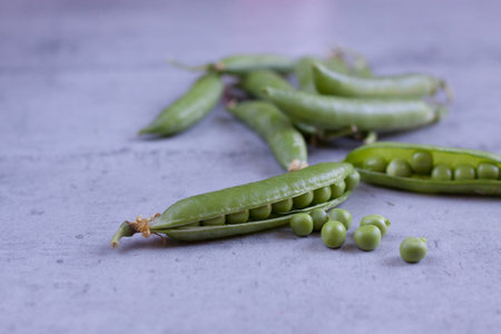 Open green pea pods on concrete background. Horizontal, close up.の写真素材