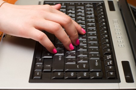 Female hand on the laptop keyboard close up.の写真素材