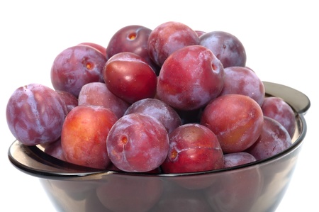 Ripe plums on a plate isolated on a white background.の写真素材