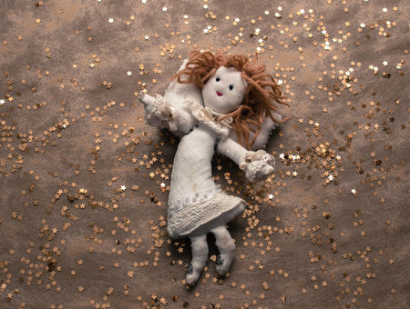 Handmade linen angel on golden background with golden stars