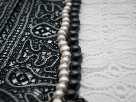 Black and white pearls on balck and white lace backgroundの写真素材