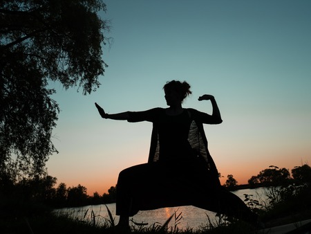 Kung fu woman in harem pants on sunset backgroundの写真素材