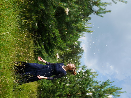 young woman in evening gawn in forest with feathersの写真素材