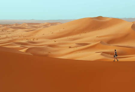 Man walking in desert on duna edgeの写真素材