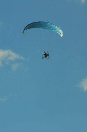 A paraglider on a flight in the clear sky