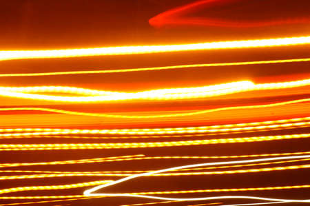 Neon lights - warm-colored light effects on a black backgroundの写真素材