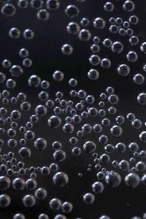 Magical air bubbles in a dark space with a metallic glowの写真素材