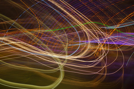 Colorful threads and ribbons interspersed with fancy light neon lights on a dark background.