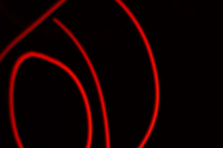 Red smeared luminous neon on black background. Irregular lines of energy in space. Composition of red light, traces of red path. Illustration 3d - being a background for inscriptions or graphics.の写真素材