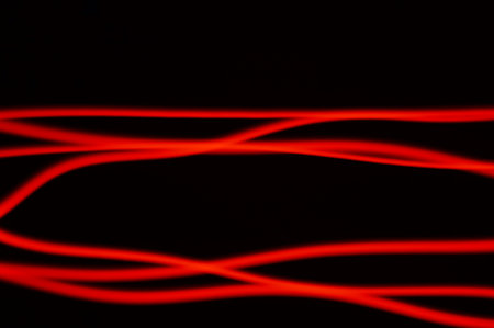 Red smeared luminous neon on black background. Irregular lines of energy in space. Composition of...