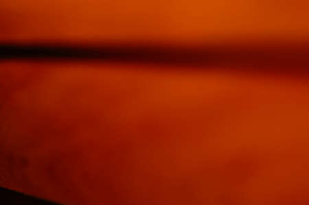 Orange and black smudged abstract background. Honey-colored horizon for text and graphics. Soft transition from light to dark. Fiery, shimmering glow.の写真素材