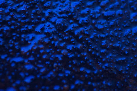 Abstract blue mysterious background. Rough texture in dark light. Oily, oily ooze with bubbles and lumps. Dark uneven background with reflected blue light. 3d illustration with gestural texture.の写真素材