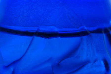 close up of a blue plastic bottle with water droplets on itの写真素材