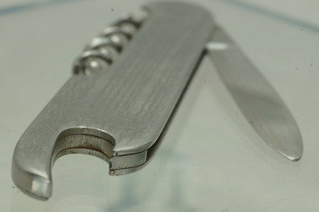 Close-up of a stainless steel knife on a glass table.の写真素材