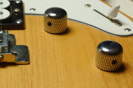 detail of an electric guitar on a wooden background, with selective focus