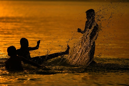 Silhouette of young boys playing during sunset at Koh Samui in Thailandの写真素材